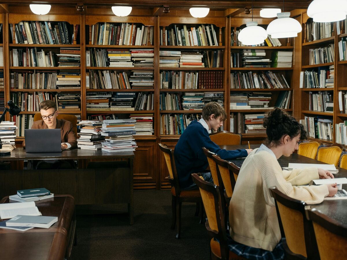 Wissenschaftliche Bibliothek mit Papierstapeln, ruhiges Leselicht